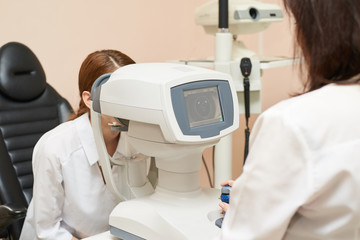 Wall Mural - ophthalmologist doctor in exam optician laboratory with female patient. Eye care medical diagnostic. Eyelid treatment