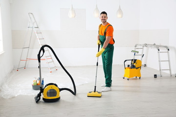 Canvas Print - Professional janitor cleaning floor with mop after renovation