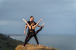 © Daria - Akroyoga in nature. Fresh air, free space, untouched by human nature outside the city in the sun set. Talented athletes doing stretching poses. Sportsman holding girl's leg, they look at the sea.