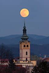 Supermoon over historical centre of Banska Bystrica. Middle-age castle Barbican in central Slovakia. Town fortification with full moon.