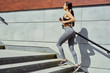© smmartynenko - sportive young brunette woman walking on stairs. Beautiful fitness girl in stylish sportswear outdoors. sport and healthy lifestyle concept.
