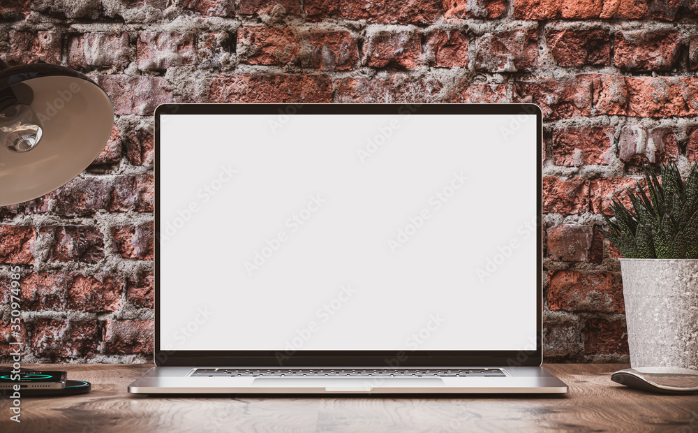 Laptop with blank screen on wooden table in loft interior with vintage brick wall - obrazy, fototapety, plakaty 