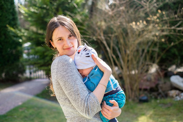 mother holding baby in a park outdoor. portrait of mother and child