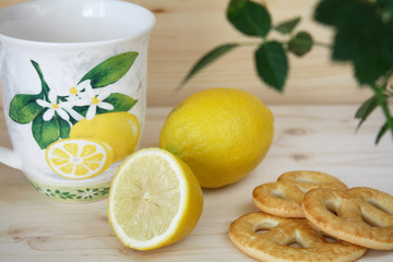 Cup, cookie and lemon on a wooden table