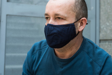 Portrait of man  with homemade fabric mask to protect against the coronavirus pandemic in outdoor