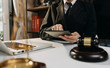 © ARMMY PICCA - Justice and law concept.Male judge in a courtroom with the gavel, working with, computer and docking keyboard, eyeglasses, on table in morning light