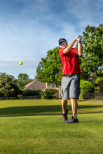 Man Teeing Off In The Tee Box, Playing Golf