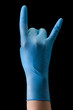 Doctor's hand in medical gloves showing devil horns gesture isolated on black