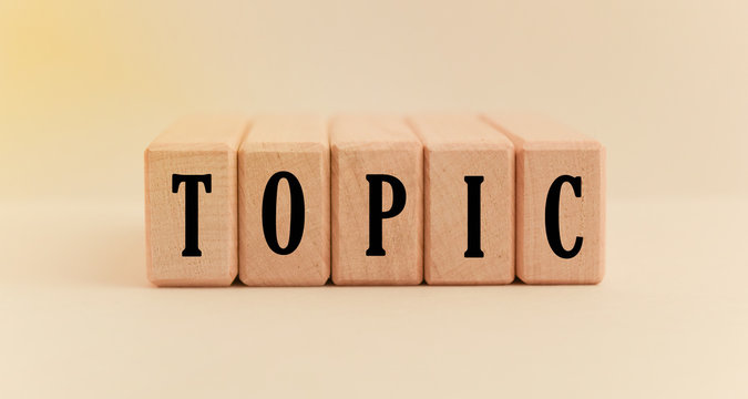 Concept word forming on wooden cube on white background - topic