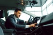 © Serhii - Handsome bearded businessman is sitting in a new car in car dealership