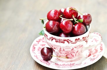 Poster - juicy ripe cherries in a beautiful porcelain cup. close-up, blurred focus. copy space