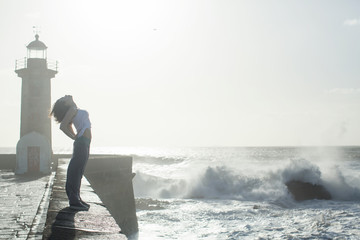 Mixed-race woman having fun and dancing of ocean promenade. Porto, Portugal.