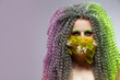 Virus Protection Ideas. Portrait of Positive Caucasian Girl With Frizzy Colorful Hair and Flowery Facial Protective Mask.