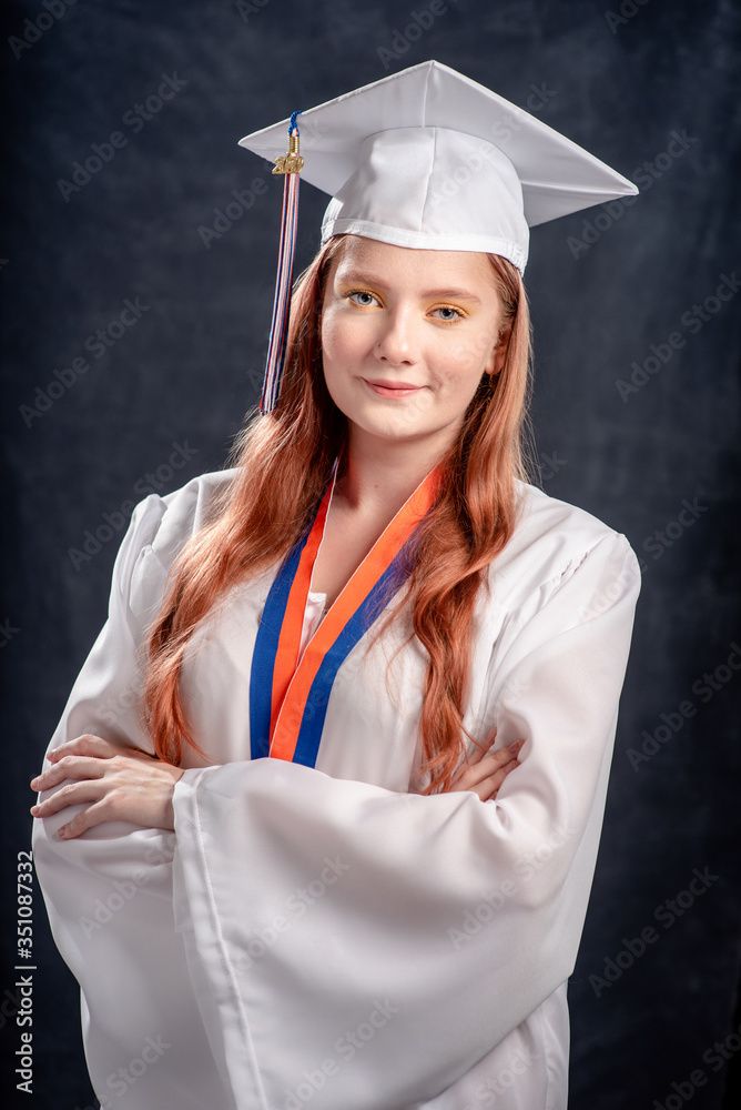 portrait of a high school girl wearing graduation white gown and cap -  studio shot on black school board background Stock Photo | Adobe Stock