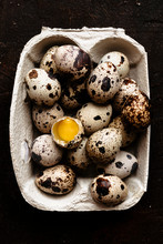 Broken Quail Egg And A Group Of Eggs Into A Carton
