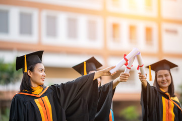 Wall Mural - A female graduate who holds a university diploma holds a diploma presented to the front