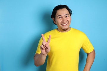 Young Man Shows Number Two or Peace Sign Gesture