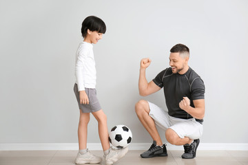 Sticker - Father and little son with soccer ball near grey wall