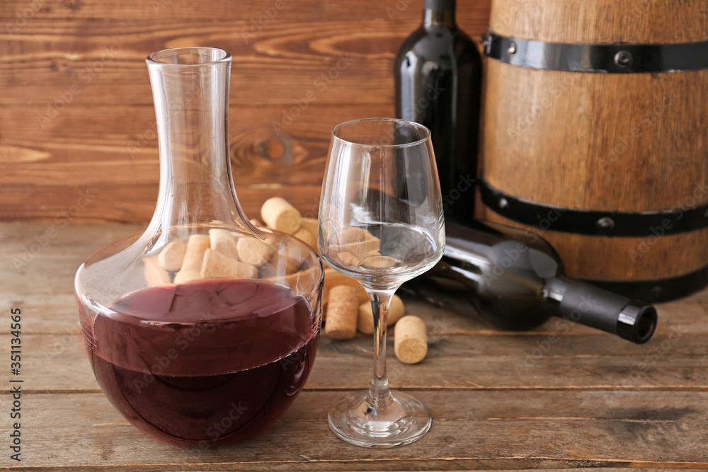 Decanter with bottles of wine and glass on wooden background - obrazy, fototapety, plakaty 