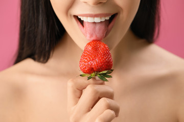 Wall Mural - Sexy young woman with strawberry on color background, closeup