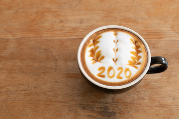 Wall Mural - hot coffee with foam milk art 2020 on wooden table, latte art coffee