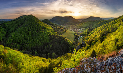 Wall Mural - Green landscape with village, mountain and rocks at sunset, Nature