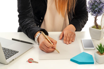 A female real estate agent takes notes in her office