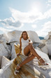 © olgalisa88 - Girl with long hair in white dress poses on a large rock of marble