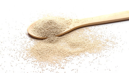 Dry yeast with wooden spoon isolated on white background