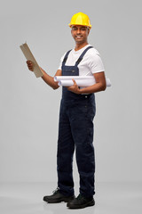 Poster - profession, construction and building - happy smiling indian builder in helmet with blueprint and clipboard over grey background