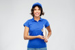 © Syda Productions - mail service and shipment concept - happy smiling delivery girl in blue uniform with clipboard over grey background
