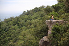 Woman Sitting On A Cliff At Mor Hin Khao National Park In Chaiyaphum, Thailand
