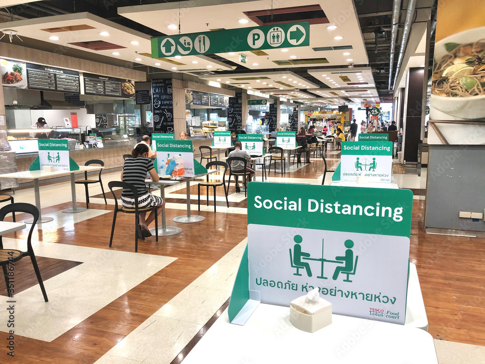BANGKOK, THAILAND- June 21, 2020: Social distancing for COVID-19 disease pandemic prevention in Tesco Lotus food court dining table public area for new normal keeping people distance - obrazy, fototapety, plakaty 