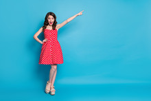 Full Length Photo Of Attractive Lady Hold Arm Direct Finger Far Away Traveler Showing Way Excited Mood Wear Red White Dotted Retro Dress Summer Open Toe Shoes Isolated Blue Color Background