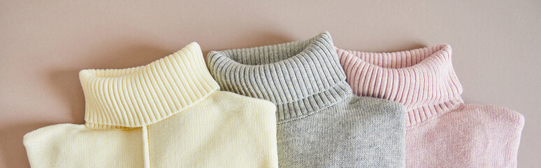 Wall Mural - top view of pink, beige and grey knitted soft sweaters, panoramic shot
