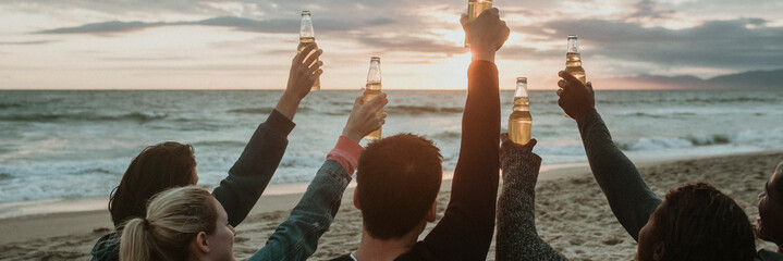 Wall Mural - Happy friends toasting at the beach