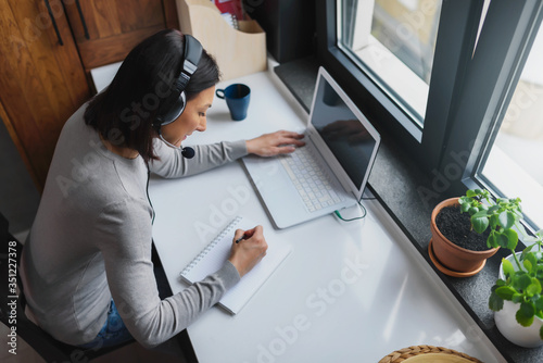 Cuadros en Lienzo Young Woman Sitting in front of Laptop Computer at Home