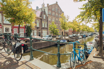 HAARLEM, NETHERLANDS, AUGUST 2019: Canal with historic houses in old Haarlem, the Netherlands, with lilac flowers. Europe tourism