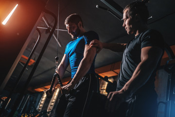 Wall Mural - young man has workout with personal trainer in modern gym