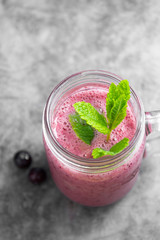 Wall Mural - Fresh fruit berry smoothie in glass jar with mint leaves, grey background. Detox, summer drink.