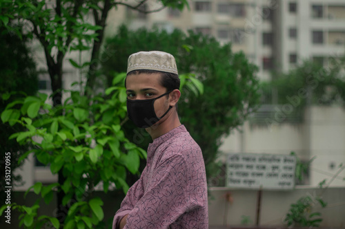 Fotografía Muslim boy with traditional punjabi wears protective mask and celebrating ramada