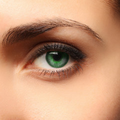 Close up picture of woman’s green eye with minimum make up