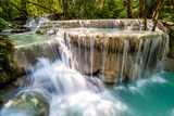 Fototapeta Las - Waterfall and blue emerald water color in Erawan national park. Erawan Waterfall tier, Beautiful nature rock waterfall steps in tropical rainforest at Kanchanaburi province, Thailand