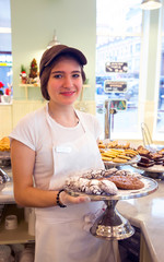 Wall Mural - Smiling girl with cookies at the bakery counter reflex