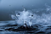 Boiling Water Splash With Steam On Dark Blue Background Closeup