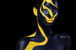 © Mike Orlov - Woman with black body paint. Cheerful young african girl with art bodypaint. An amazing model with yellow makeup. Closeup face.