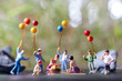 Miniature people : Happy family sitting on the mat during a picnic in a park