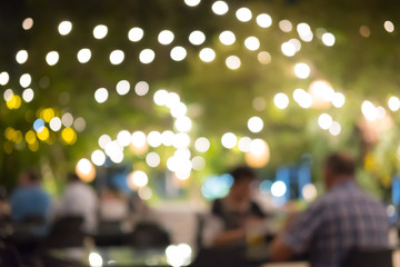 Blurred image bokeh of people sitting on the table for dinner, talking and drinking beer in the restaurant