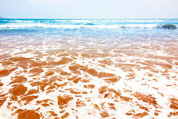 Blue ocean waves and yellow sand