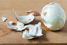 Slices Of Peeled Egg And Shell On The Board